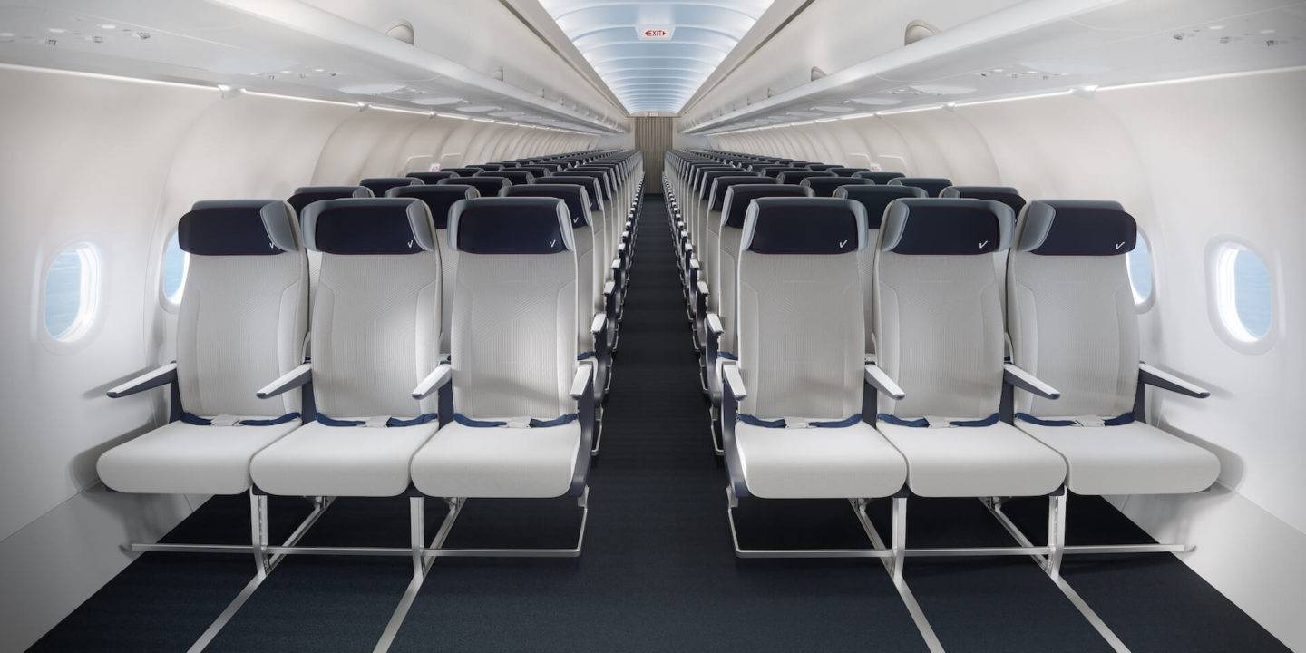 Front view of an economy class cabin showing light grey contemporary seats with dark blue headrests