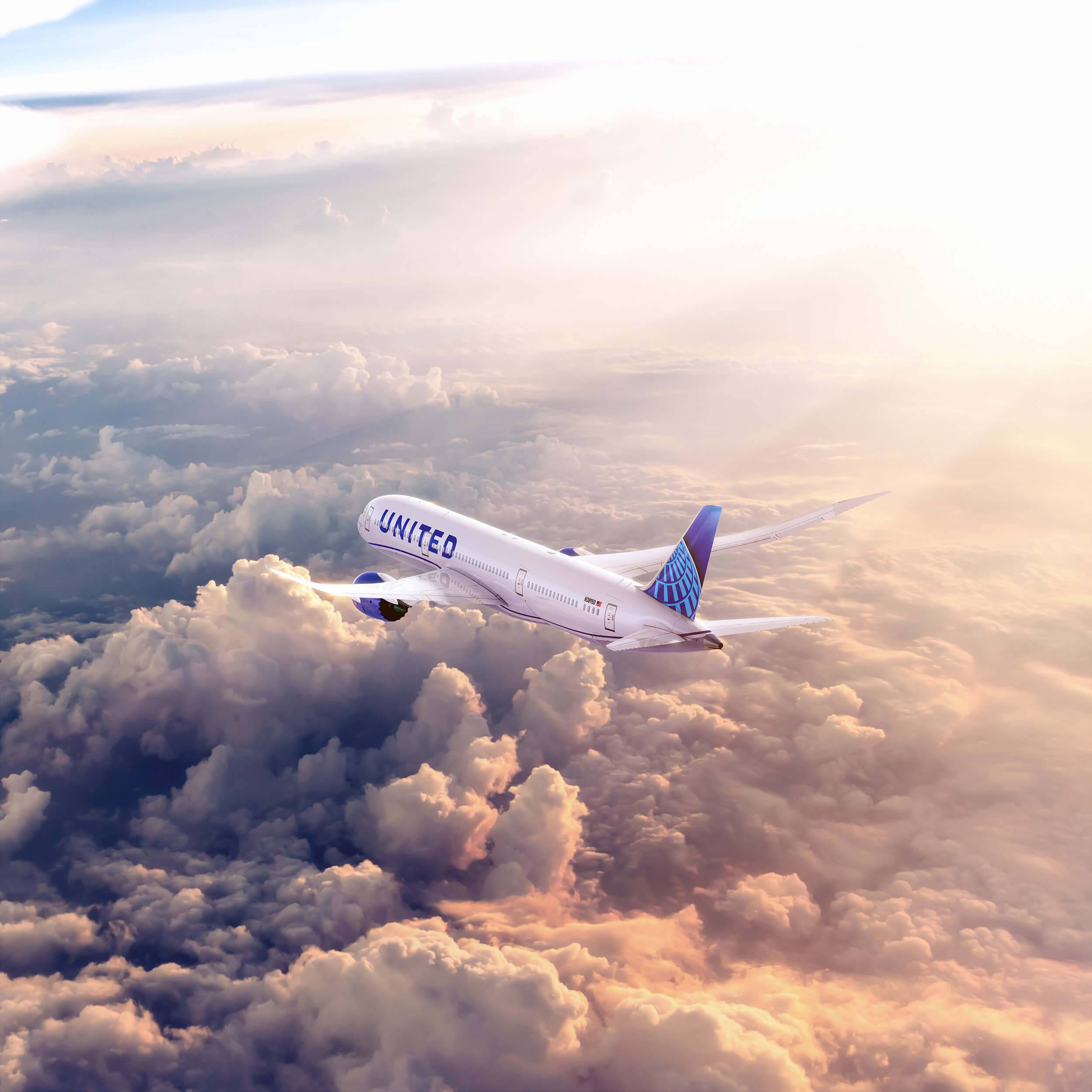 United Airlines plane flying above the clouds